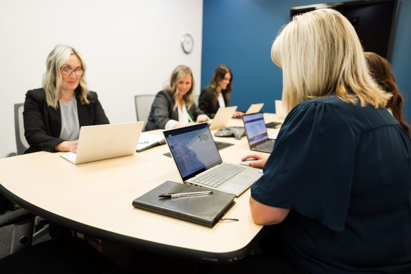 Women in a meeting using laptops.