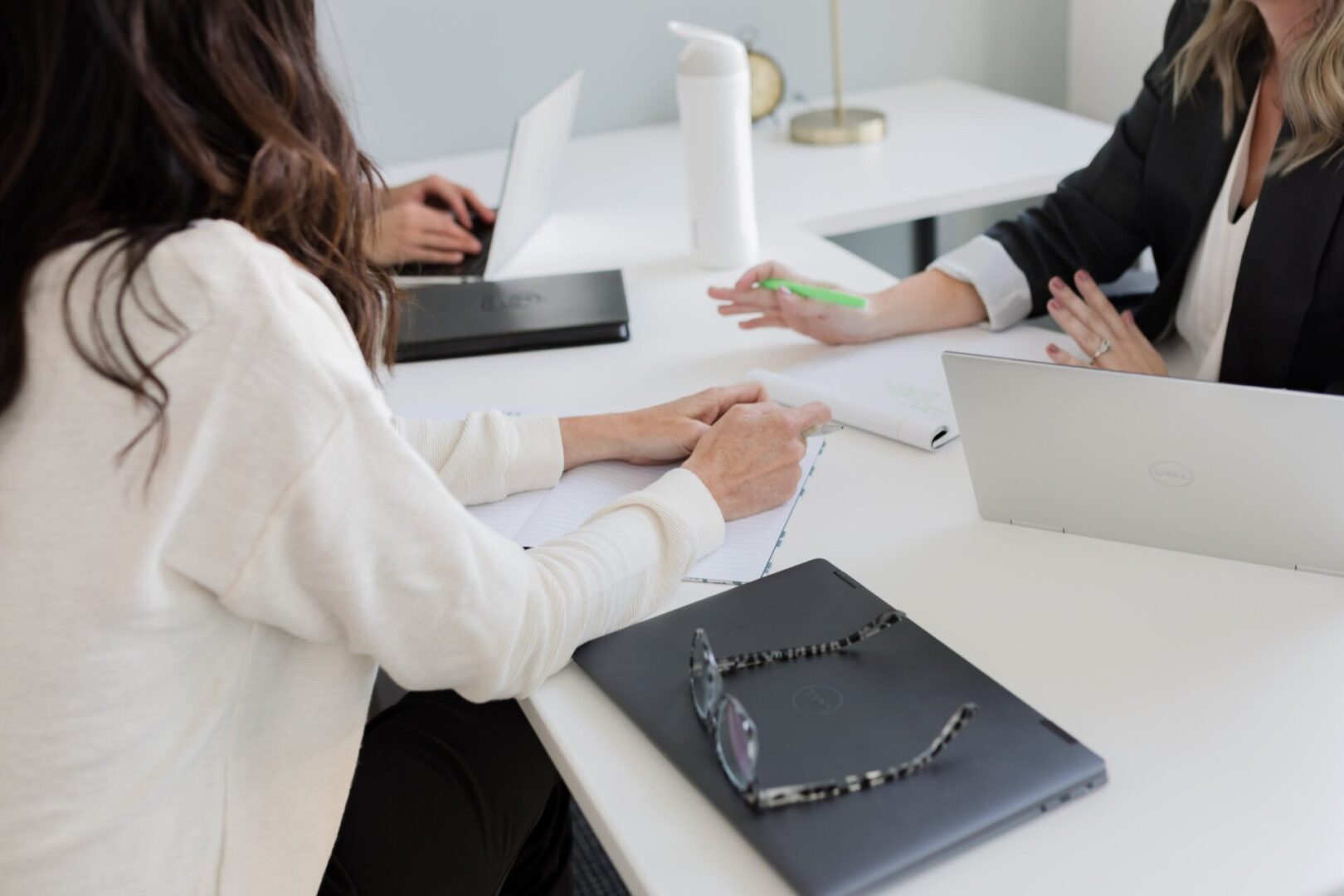 Two people sitting at a table with papers and laptop.