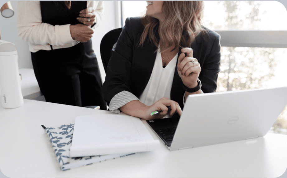 A woman sitting at a table with her laptop.