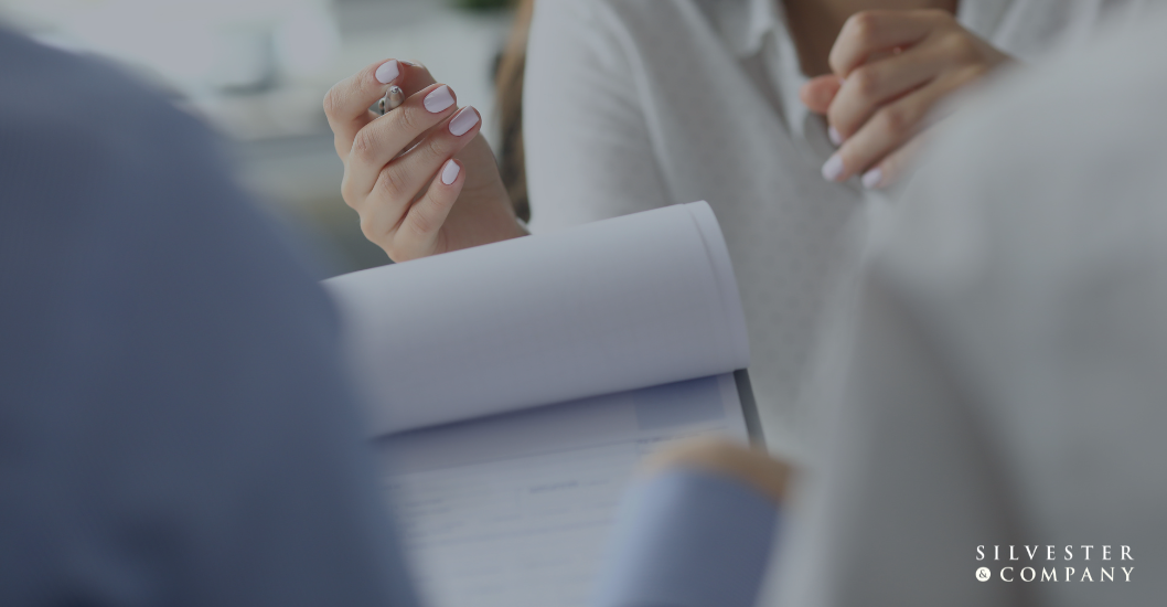 Person signing a document in meeting.