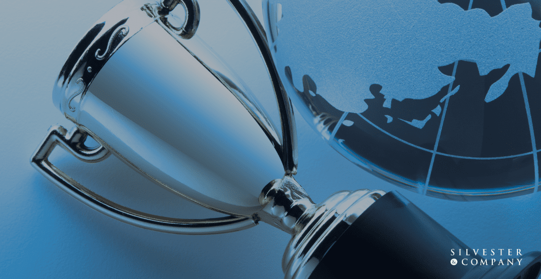 Silver trophy on a blue globe.