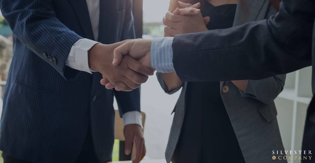 Two businessmen shaking hands in a meeting.