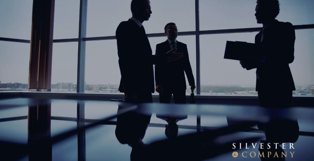 Silhouettes of businessmen in an office.