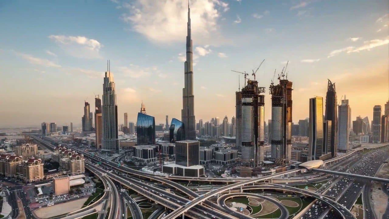 Aerial view of Dubai skyline at sunset.