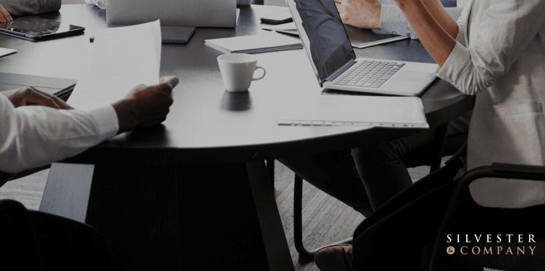 Business meeting at a table with a laptop.