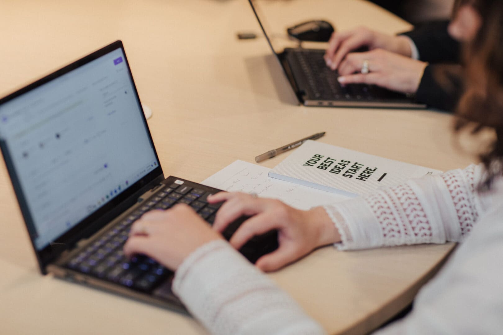 Woman working on a laptop at a desk.