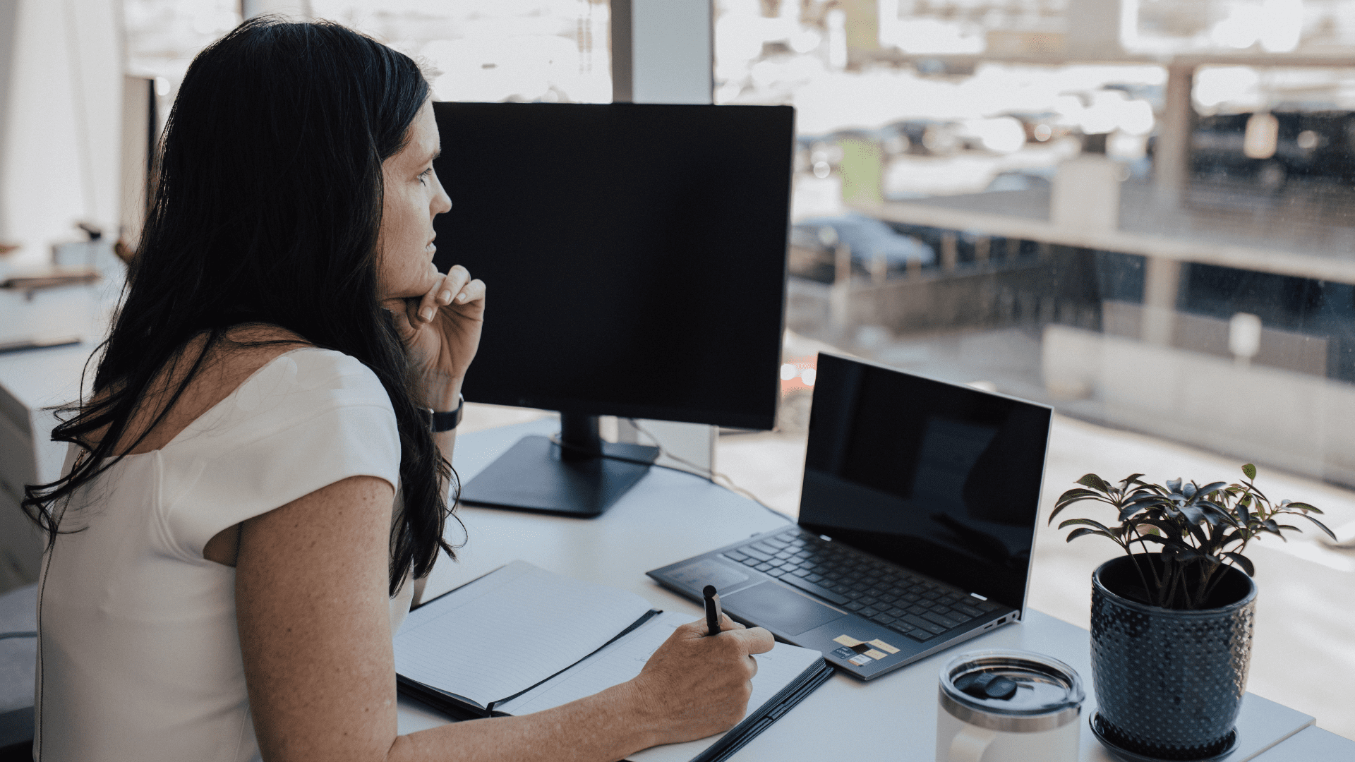 Woman working at a desk with a laptop.