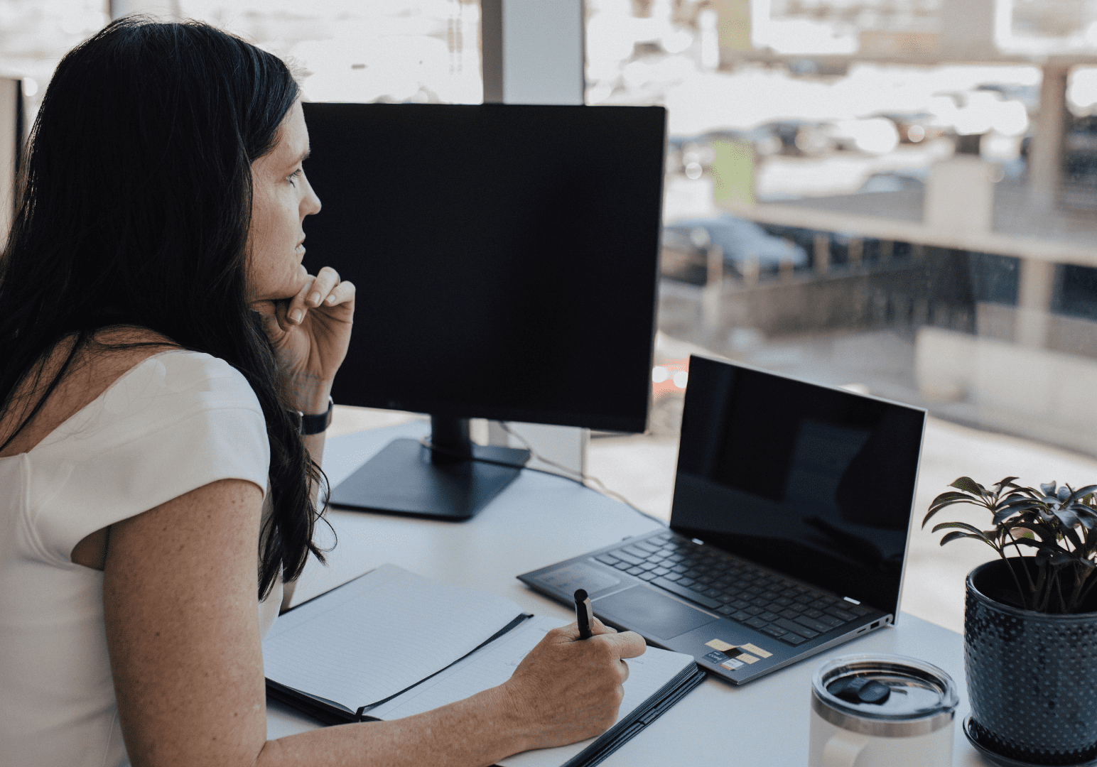 Woman working at a desk with a laptop.