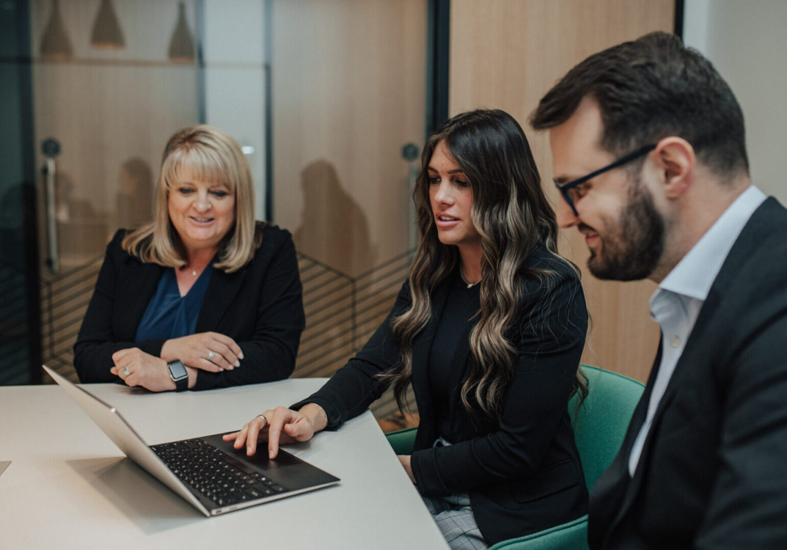 Three businesspeople collaborating at a desk.