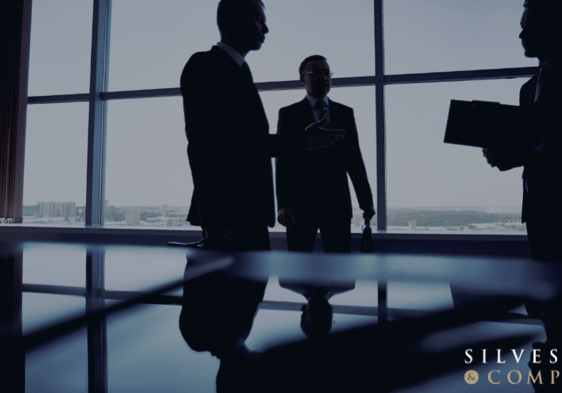 Silhouettes of businessmen in an office.